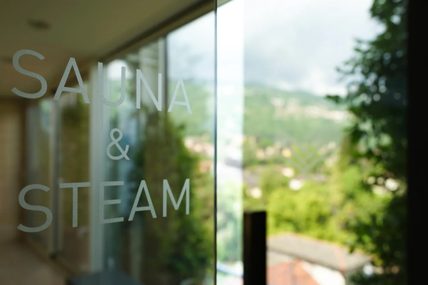 Close-up du texte sauna et vapeur sur fenêtre en verre